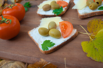 Sandwich with green olives and cream cheese, tomato on a cutting board. Healthy sandwich. Food concept. 