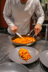 chef preparing pasta in kitchen - 684229527