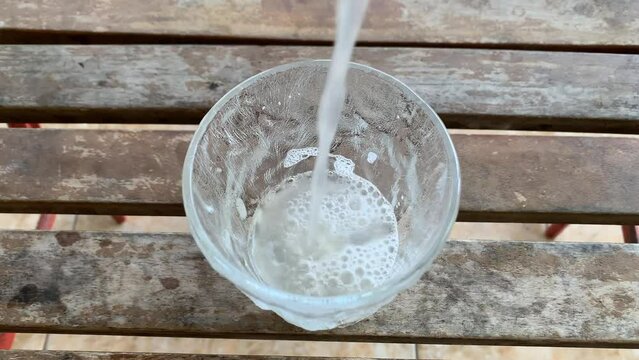 Pouring Tuak Manis (Arak) or Palm Wine in a glass.