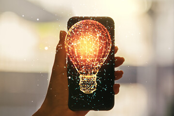 Creative light bulb illustration and hand with mobile phone on background, future technology...