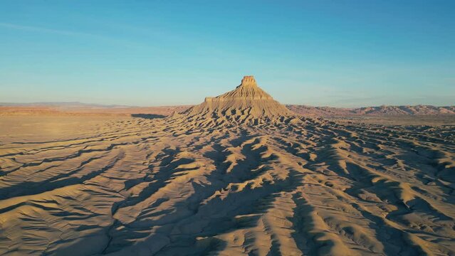 Drone footage, panning backwards, of Factory Butte near Hanksville, Utah, USA. No people.
