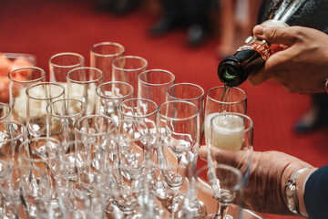Close up photo of business owner pouring champagne for his employees at the end of the year....