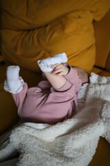 newborn lying on the sofa playing with his feet
