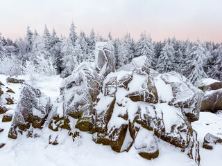 Winter wonderland in the Harz mountains, Harz National Park in Lower Saxony, Germany. Snow and frost covered rock formation in the forest.