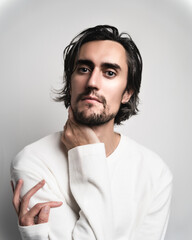 young guy in a white long sleeve on a white background portrait high key
