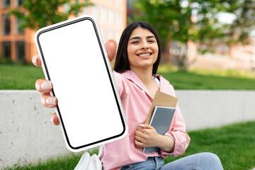 student lady showing large phone with empty screen outdoors