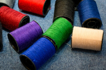 Heap of colorful threads bobbins on  table. 