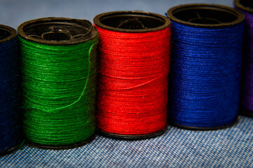 Heap of colorful threads bobbins on  table. 
