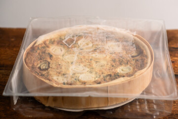 Culinary Symphony: A symphony of flavors is embodied in a leek and egg quiche placed gracefully on a wooden surface
