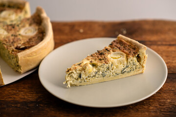 Comfort Food Bliss: A comforting leek quiche adorned with eggs graces the wooden surface, promising...