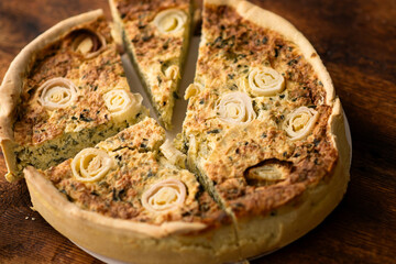 Comfort Food Bliss: A comforting leek quiche adorned with eggs graces the wooden surface, promising...