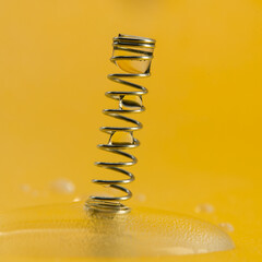 water drops on the wire spring with yellow background