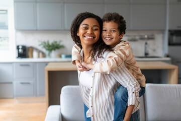 Young Happy Black Woman And Her Cute Preteen Son Posing At Home