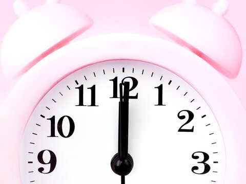 Pink alarm clock at 12am 12pm close up