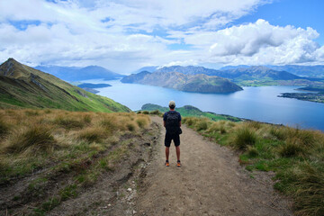 hiker in the mountains at roys peak in new zealand
