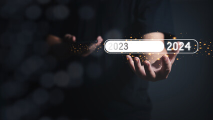 The virtual loading progress bar on hand for New Year Changing the year 2023 to 2024. The new year...