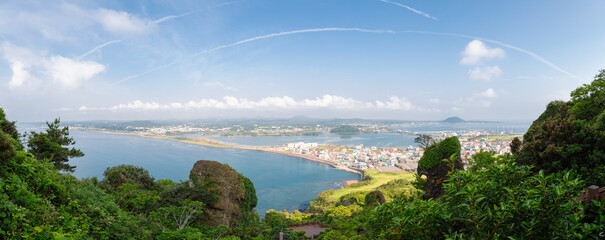 Panoramic view of sea and city from Seongsan Ilchulbong Tuff Cone in Jeju Island, Korea - obrazy, fototapety, plakaty