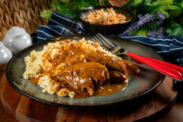 Braised pork neck in own sauce served with barley groats and salad.