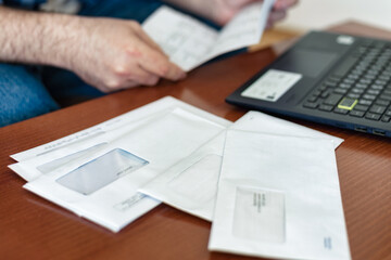 Man checking expensive utility bills sitting at home