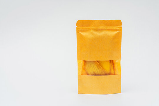dried mango slices in a bag on a white background. dehydrator-dried mango for cooking and drinking. mango chips in a pack on a light background