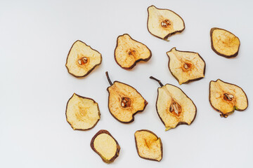dried pear slices on a white background. banana dried in a dehydrator for preparing food and...