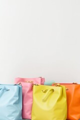 Multicolored blue, orange, pink, yellow leather bags on a white background with copy space for text, advertising. Shopaholic, shopping concept shopping.