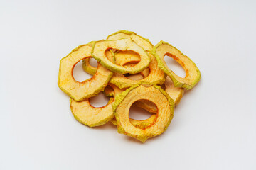 Obraz na płótnie Canvas dried apple slices on a white background. apple dried in a dehydrator for preparing food and drinks. apple chips on a light background