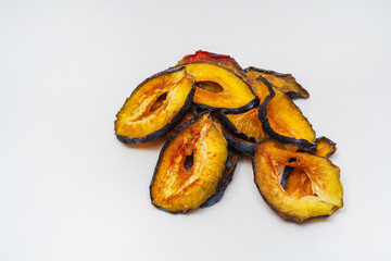 dried plum slices on a white background. plums dried in a dehydrator for preparing food and drinks. plum chips on a light background