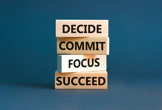 Decide commit focus succeed symbol. Concept word Decide Commit Focus Succeed on wooden block. Beautiful grey background. Business decide commit focus succeed concept. Copy space.