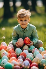 Smiling young boy holding a red Easter egg surrounded by a collection of vibrant eggs.