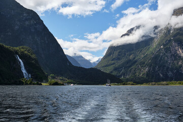 Boat in fjords of milford sound, new zealand