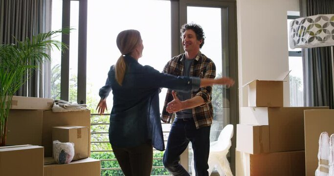 Happy couple, box and hug for new house, interior or apartment in real estate together. Man and woman hugging with boxes for property, investment or relocation and renovation in buying success