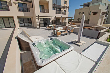 Roof terrace patio with hot tub and chairs in tropical luxury holiday villa