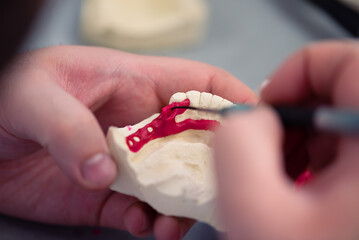 Dental technician working with tooth denture at prosthesis laboratory