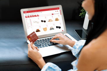 Young woman using laptop with credit card for internet banking, online shopping E commerce by...