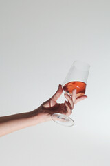 A hand holding a glass with rose wine