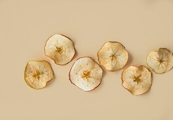 Dried apple and pear slices on a beige background