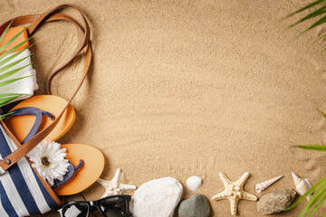 Woman's beach accessories bag, straw hat, flip flops, shells, sunglasses, palm leaves on sand...