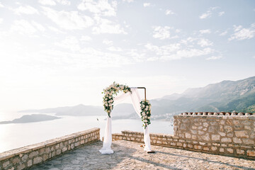 Rectangular wedding arch stands on an observation deck in the mountains above the sea