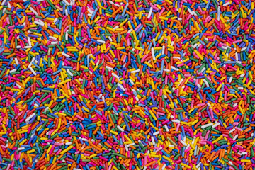 Fototapeta premium background of multi-colored sprinkles for sweets and multi-colored dragees or sweets. The concept of celebrating a birthday, party or other holidays. trendy, sweet background