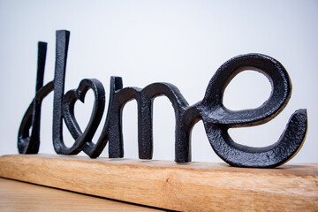 home, decorative figure with the word home made of black metal and wood on a white background
