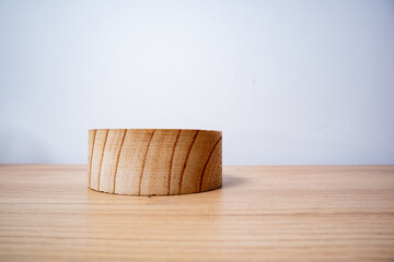 wooden circular container on wooden surface, white background, horizontal photo