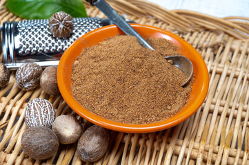 Tasty winter spice whole dried and ground powder nutmeg, used as an ingredient in many dishes,...