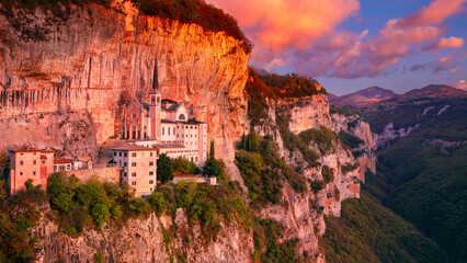 Madonna della Corona, Italy. Aerial image of the unique Sanctuary Madonna della Corona (Sanctuary of the Lady of  the Crown) was built in the rock, located in the Alps in Italy at autumn sunrise.