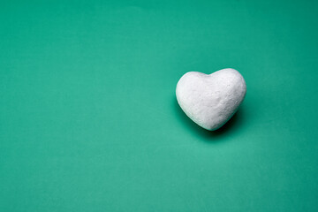 White heart representing the purity of love on a green background.