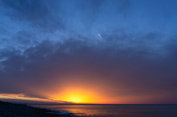 Sunset sky over the sea. Yellow, orange, red, purple and blue gradient.