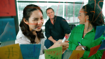 Portrait of professional diverse business team brainstorming marketing idea on colorful sticky...