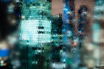 Raindrops on window glass. Selective focus. Rainy city background.