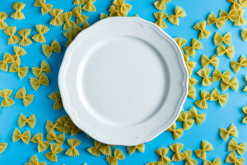 Raw pasta farfalle with copy space on blue background