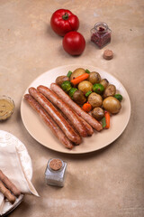 Chicken sausages with a side dish of new potatoes and vegetables
